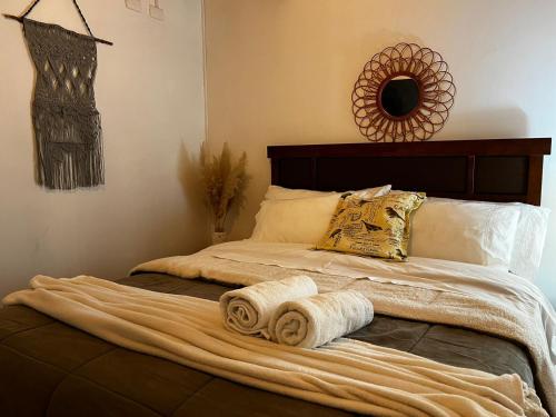 a bed with two rolled towels on it at Cabañas Alto Centro, Departamento N 3 in La Unión