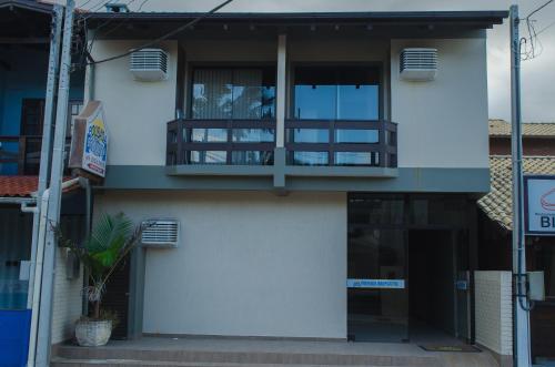 a white building with a balcony on the side of it at Pousada Bronzatto in Garopaba