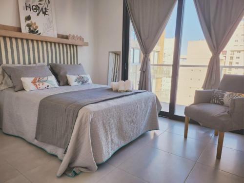 ein Schlafzimmer mit einem Bett, einem Stuhl und einem Fenster in der Unterkunft Dptos amoblados NQN - Excelente ubicacion- ZONA CENTRO in Neuquén