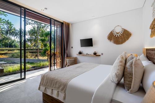a bedroom with a bed and a large window at Villa Jehanne by BaliSuperHost in Ubud
