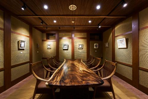 a conference room with a wooden table and chairs at Shima-Onsen Toshimaya in Nakanojo