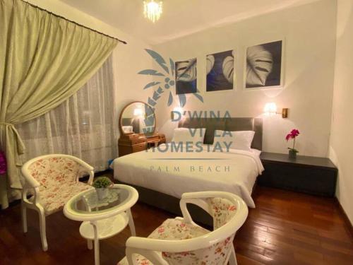 1 dormitorio con 1 cama, 2 sillas y mesa en D'Wina Villa Homestay en Papar