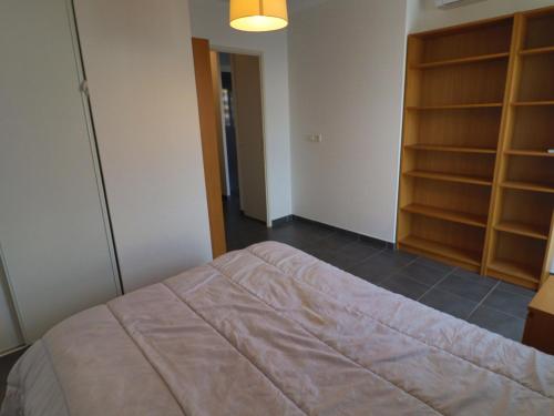 une chambre avec un lit et une étagère dans l'établissement Charmant 2 pièces avec clim, parking et piscine, à 300m de la plage - Sète - FR-1-472-189, à Sète