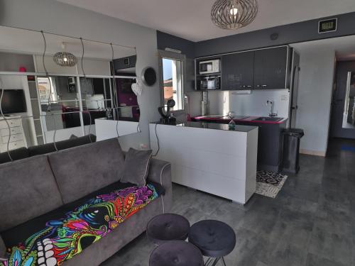 un salon avec un canapé et une cuisine dans l'établissement Charmant 2 Pièces avec Terrasse et Parking à Sète - FR-1-472-191, à Sète