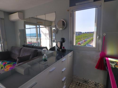 un salon avec un canapé et une grande fenêtre dans l'établissement Charmant 2 Pièces avec Terrasse et Parking à Sète - FR-1-472-191, à Sète