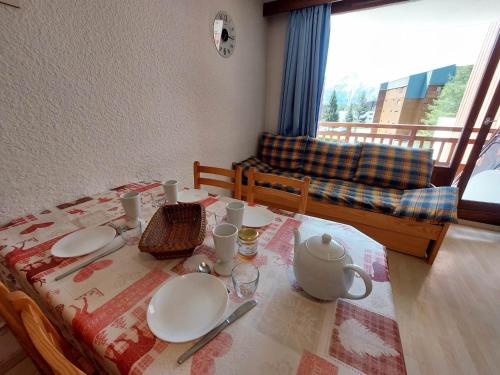 una mesa de comedor con platos y una tetera. en Appartement Les Deux Alpes, 2 pièces, 6 personnes - FR-1-516-206 en Les Deux Alpes