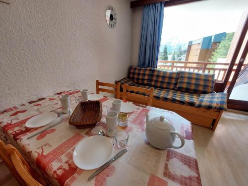 ein Esstisch mit Tellern und einer Teekanne darauf in der Unterkunft Appart 1 chambre au centre, 3éme étage, 6 pers, pied des pistes - FR-1-516-206 in Les Deux Alpes