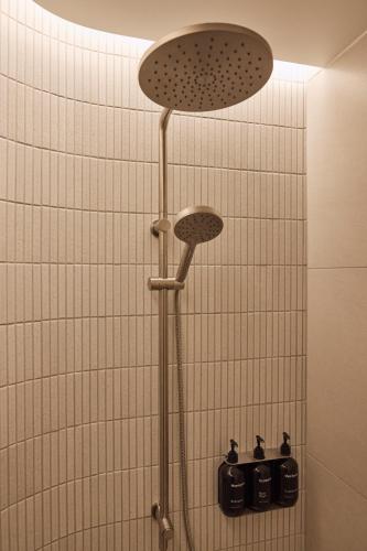 a shower with two lights on a tiled wall at Rydges Melbourne in Melbourne