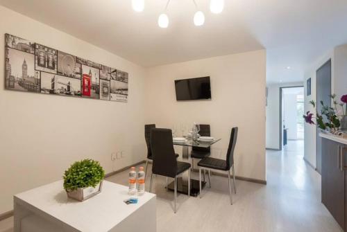 Central and cozy CDMX 1BR في مدينة ميكسيكو: غرفة معيشة مع طاولة وكراسي في غرفة