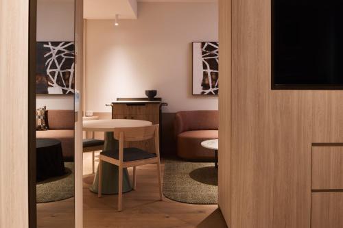 a living room with a table and a television at Rydges Melbourne in Melbourne