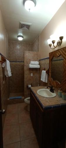 a bathroom with a sink and a toilet and a mirror at Gone Fishing Panama Resort in Boca Chica