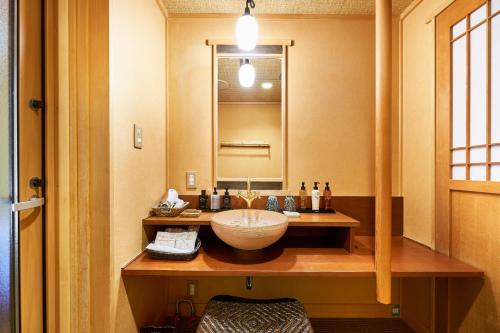 a bathroom with a sink and a mirror at Shima-Onsen Toshimaya in Nakanojo