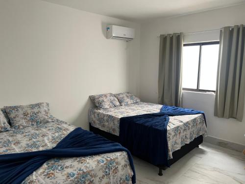 sypialnia z 2 łóżkami i oknem w obiekcie Carapibus casa de praia 02 w mieście Conde