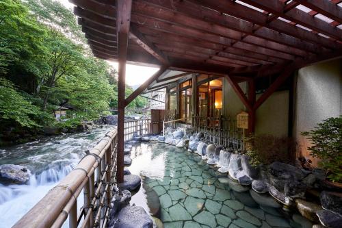 a building with a river in front of a building at Shima-Onsen Toshimaya in Nakanojo
