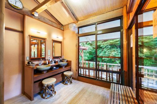 a bathroom with two sinks and a large window at Shima-Onsen Toshimaya in Nakanojo