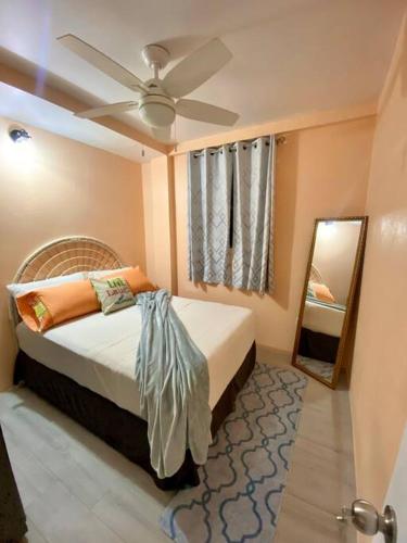 1 dormitorio con 1 cama con ventilador de techo y espejo en Hidden Zen 108 with rental vehicle access, en Castries