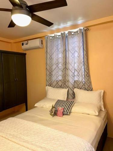 a bedroom with a bed with a ceiling fan and a window at Hidden Zen 108 with rental vehicle access in Castries