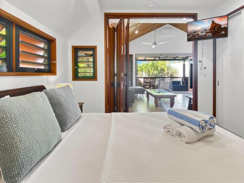 Un dormitorio con una cama blanca con una toalla. en Pure Magnetic Villa 9 en Nelly Bay