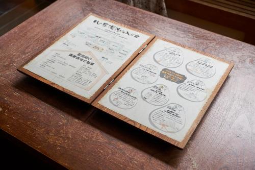 a table with two pamphlets sitting on top at Shima-Onsen Toshimaya in Nakanojo