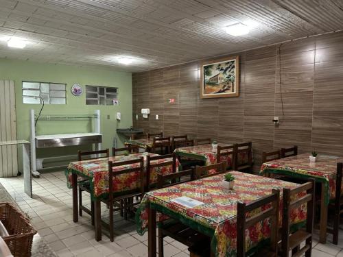 Pousada Vale do Gravatá في غرافاتا: مطعم بطاولات وكراسي وبيانو