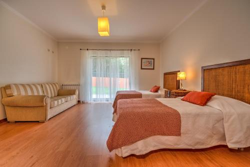 een slaapkamer met 2 bedden en een bank bij A casa das minhas netas in Caldas da Rainha
