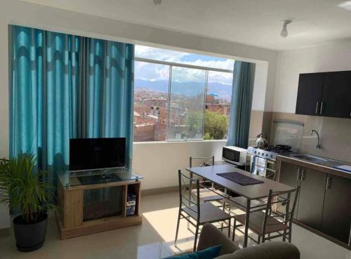 a living room with a table and a large window at Departamento en centro histórico en 4to piso in Ayacucho