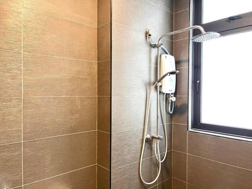 a shower in a bathroom with a shower head at Urban Vista @ The Quartz Residence: City Center Retreat with InfinityPool in Melaka
