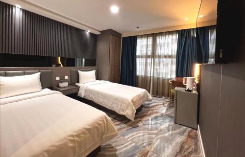香港にあるHennessy Hotelのベッド2台とデスクが備わるホテルルームです。