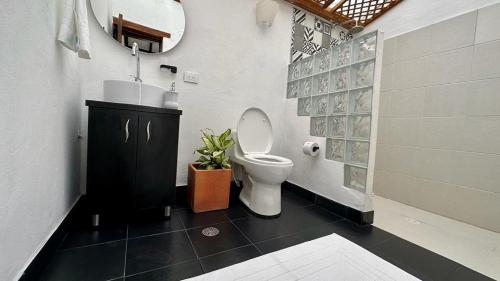 y baño con aseo, lavabo y espejo. en Casa Clásica con Chimenea!, en Villa de Leyva