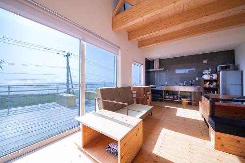 uma sala de estar com uma grande porta de vidro deslizante com vista para o oceano em Sunny SIDE HOUSE 