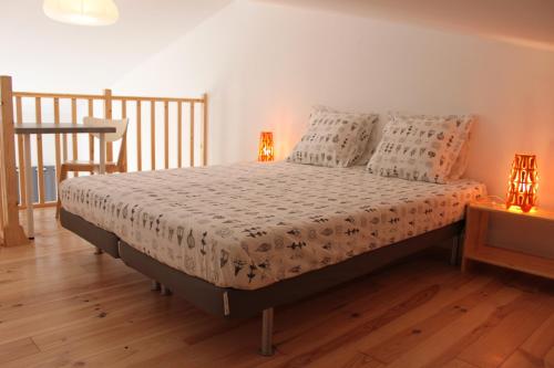 - un lit dans une chambre avec 2 lampes sur une table dans l'établissement Les Hirondelles, à La Garde