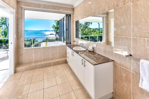 ein Badezimmer mit einem Waschbecken und einem großen Fenster in der Unterkunft Blue Water Views 16 - 3 Bedroom Penthouse with Ocean Views in Hamilton Island