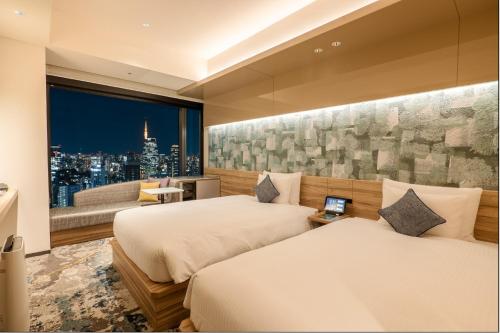 a hotel room with two beds and a window at THE BLOSSOM HIBIYA in Tokyo