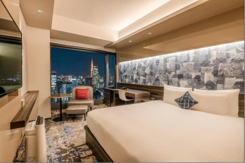 a hotel room with a bed and a view of a city at THE BLOSSOM HIBIYA in Tokyo