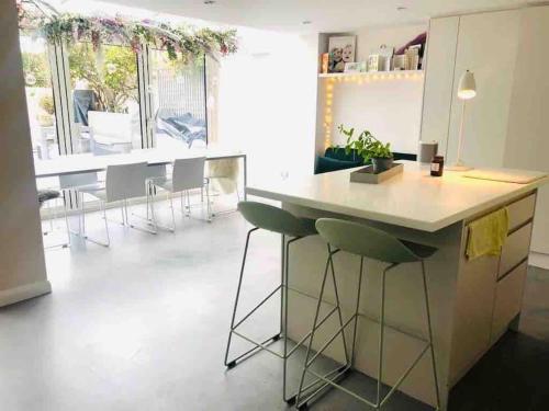 a kitchen with a counter and stools in a room at Stylish Georgian townhouse on Richmond Hill in Richmond