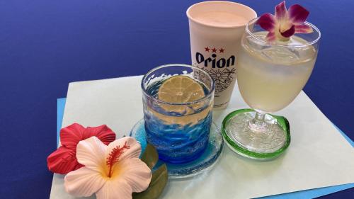 una mesa con dos vasos y una bebida y flores en Toyoko Inn Okinawa Naha Asahibashi Ekimae, en Naha