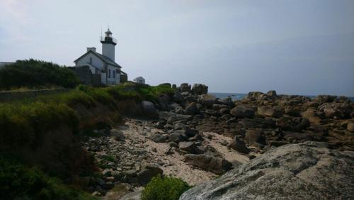 a lighthouse on the shore of a rocky beach at Les Chambres de Kermenguy in Sibiril
