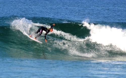 a man riding a wave on a surfboard in the ocean at A casa das minhas netas in Caldas da Rainha