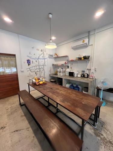 a kitchen with a wooden table in a room at Together Backpackers Hostel in Chiang Rai