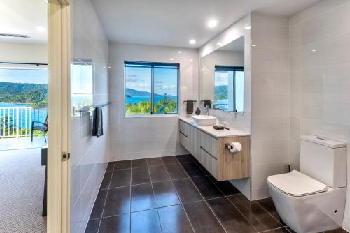 a bathroom with a toilet and a sink at La Bella Waters 5 Oceanview Private Garden BBQ Buggy in Hamilton Island