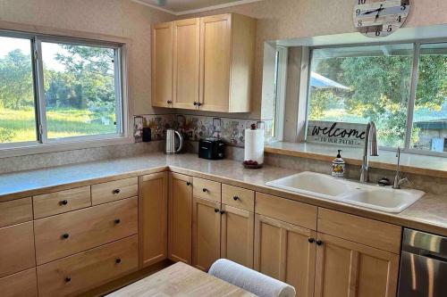 een keuken met houten kasten, een wastafel en een raam bij Julian Orchard Ranch in Santa Ysabel