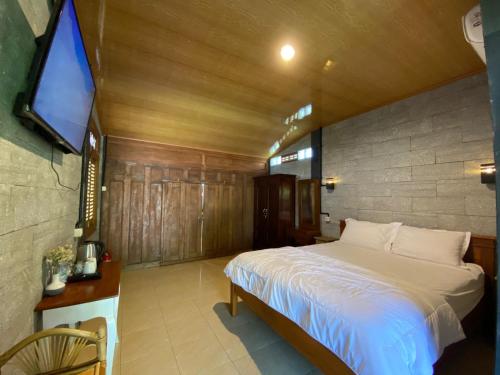 una camera con letto e TV di Djiwanta Cottage by Balkondes Sambirejo a Groyokan