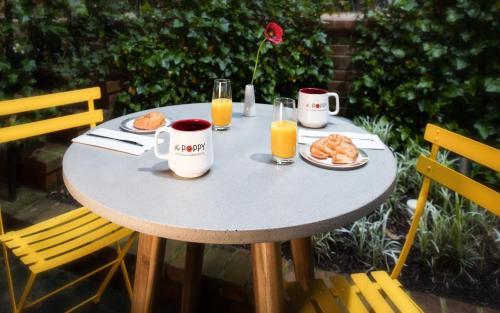 a table with a breakfast of orange juice and croissants at The Poppy Georgetown Guesthouse and Gardens in Washington