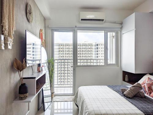 a bedroom with a bed and a large window at Studio Condo Manila by the Bay Roxas Blvd near US Embassy in Manila