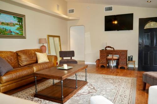 a living room with a couch and a table at Cozy Family Hideaway, sleeps 8, 4 tv's yard, shops in Simi Valley