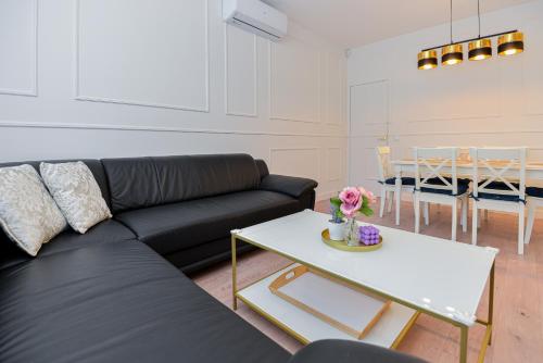 a living room with a black couch and a table at Nida family apartments in Nida