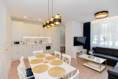a kitchen and living room with a table and chairs at Nida family apartments in Nida