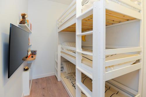 a bunk bed in a room with a tv at Nida family apartments in Nida