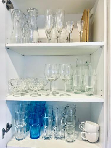 a shelf filled with glasses and other glass items at Nida family apartments in Nida