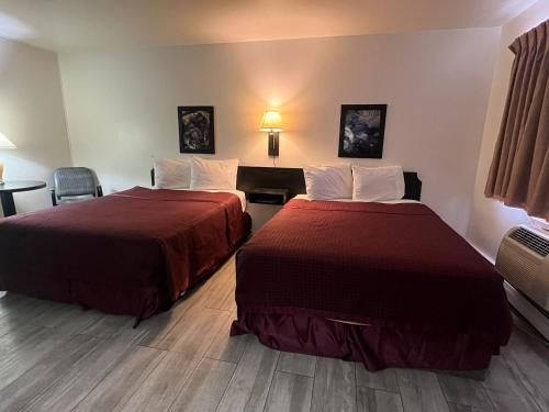una camera d'albergo con due letti e un tavolo di Central Motel a Fort Morgan